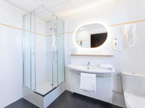 a white bathroom with a glass shower and a sink at ibis Styles Toulouse Lavaur in Lavaur