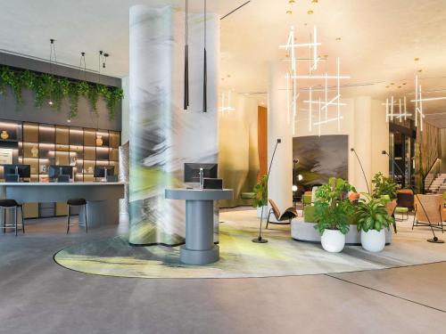 a lobby with a table and plants in a building at Novotel Dubai World Trade Centre in Dubai