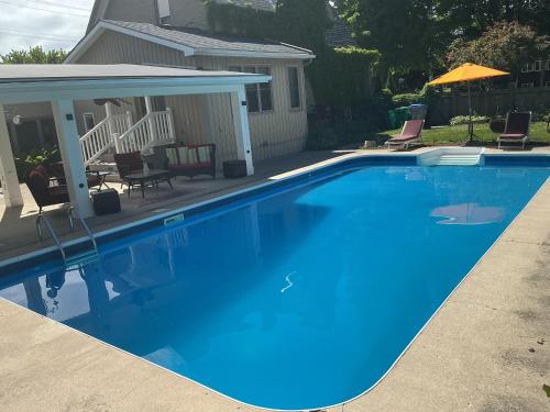 a large blue swimming pool in front of a house at Granary Guest House in Goderich