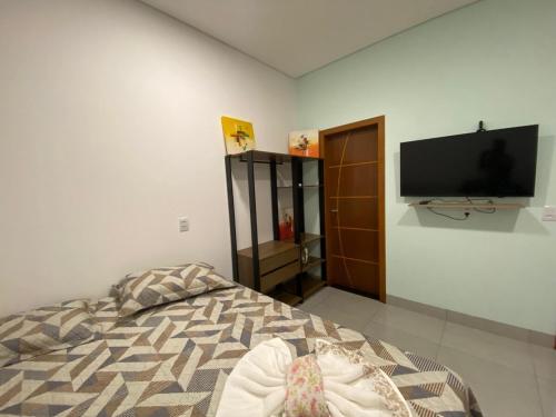 a bedroom with a bed and a flat screen tv at Lindo APTO bem localizado em Sinop! in Sinop