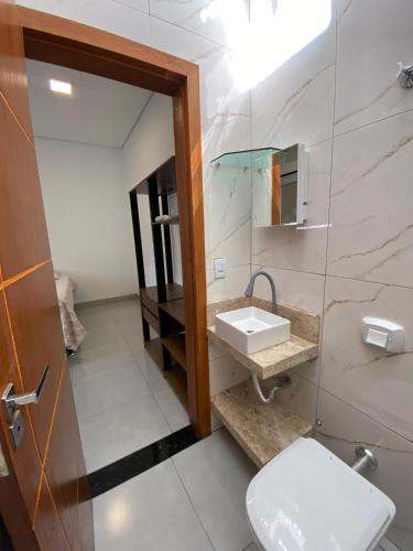 a bathroom with a white toilet and a sink at Lindo APTO bem localizado em Sinop! in Sinop
