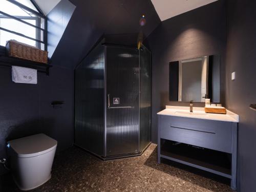 a bathroom with a shower and a toilet and a sink at Silver Beach Yuese Hostel in Beihai