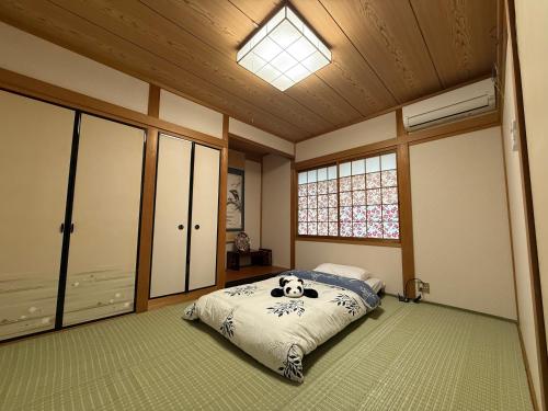 a bedroom with a panda bear on a bed at Guest House Hana in Otsu