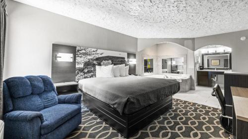 a hotel room with a bed and a chair at Super 8 by Wyndham Norman West OK in Norman