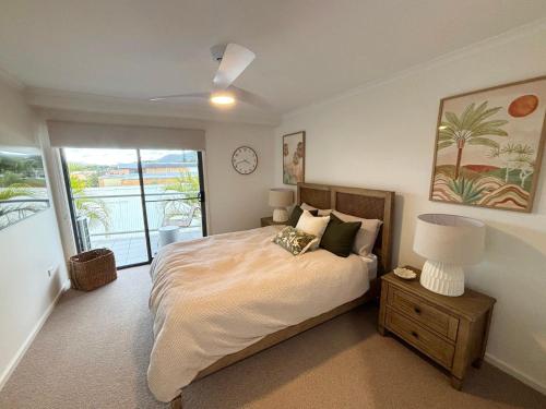 a bedroom with a bed with a clock on the wall at Jubilee Apartment 05 - Bring your own linen in South West Rocks