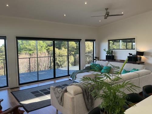 a living room with a couch and some windows at Black Hill Retreat, Ballarat in Nerrina