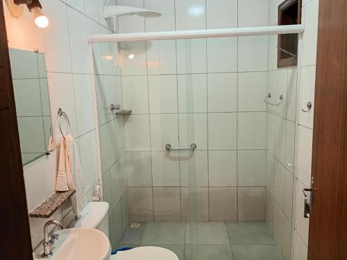 a bathroom with a shower with a toilet and a sink at Pousada Campo Alegre Eireli in Itatiaia