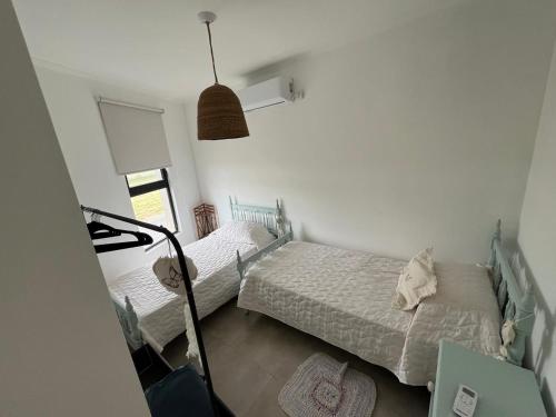 a bedroom with two beds and a lamp at Las moras quinta in San Nicolás de los Arroyos
