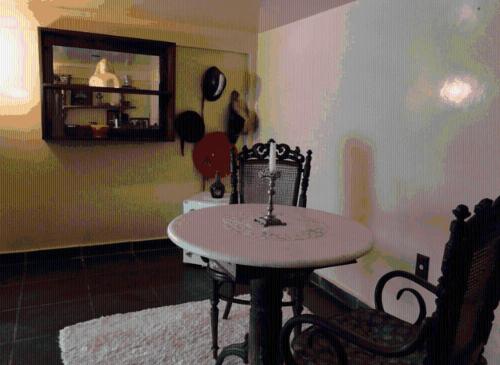 a dining room with a table and chairs in a room at Pousada Romântica Serra da Mata in Penedo