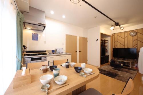 a kitchen with a wooden table with bowls on it at New コスパ重視セール開催中!久留米駅徒歩5分コンビニ1分!ファミリー 友人快適!キッズエリア大好評 in Kurume