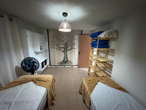 a room with two beds and a tree mural on the wall at Triplex no litoral in Matinhos