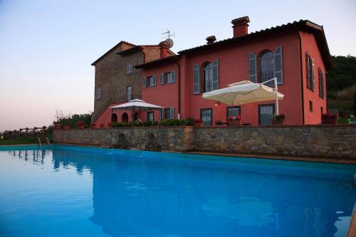 ein Haus mit einem Pool vor einem Gebäude in der Unterkunft Agriturismo Rimaggiori relaxing country home in Barberino di Mugello