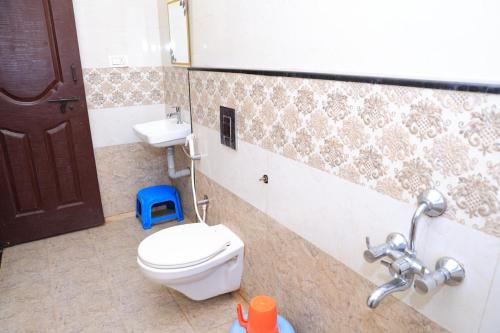 a bathroom with a toilet and a sink at Horanadu Sanman residency in Kalasa