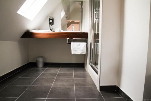 a bathroom with a sink and a mirror at Hôtel de Biencourt in Azay-le-Rideau