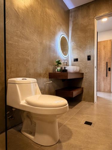 a bathroom with a toilet and a sink at Hotel Oasis AYA FE in San Isidro de El General