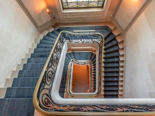 a spiral staircase in a building with a window at Mercure Le Mans Centre in Le Mans