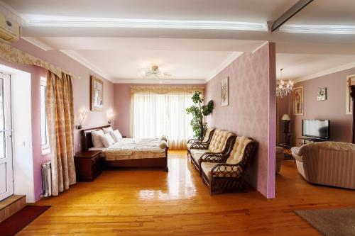 ein Wohnzimmer mit einem Sofa und einem Bett in der Unterkunft Villa Snegiri in Hursuf