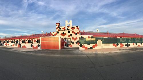 un edificio con una croce dipinta sul lato di Motel Venus Madrid Norte a Meco