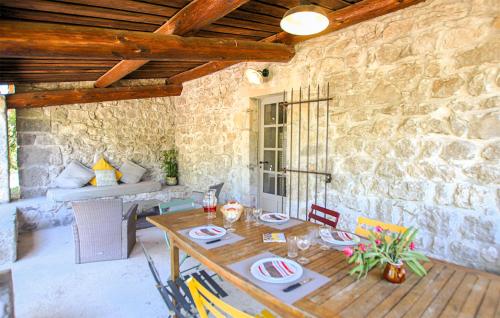 a dining room with a table and a stone wall at Stones House in Labeaume
