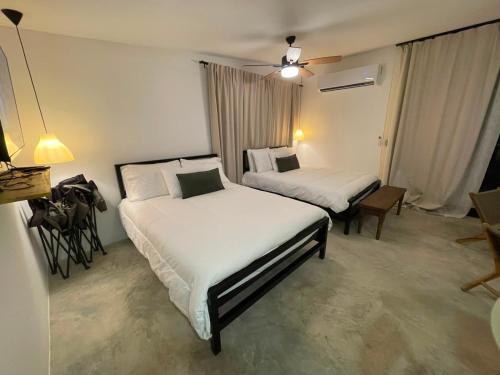 a hotel room with two beds and a table at Suerte Bella in San Carlos