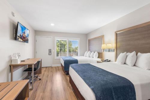a hotel room with two beds and a desk at Hotel 414 Anaheim in Anaheim