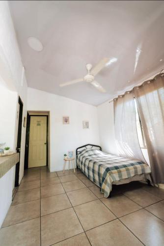 a bedroom with a bed and a ceiling fan at Las cabañas in Jacó