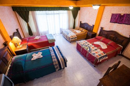 an aerial view of a bedroom with two beds and a table at Hotel Tiosh Abaj in Santiago Atitlán
