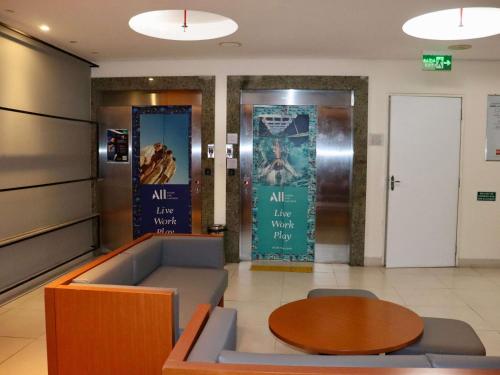 a waiting room with a table and a couch and a door at Ibis Mossoro in Mossoró