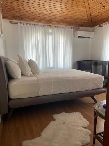 a bedroom with a large bed with a window at Oran House in Ayvalık