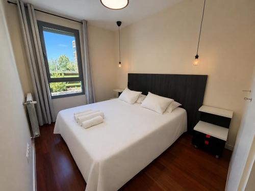 a bedroom with a large white bed and a window at Green Valley Las Margas Golf in Latas