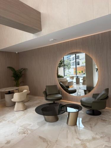 a lobby with chairs and tables and a mirror at Suite de Lujo la Carolina in Quito