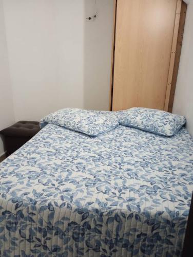 a bed with a blue comforter in a room at Apartamento lechería in El Morto de Barcelona