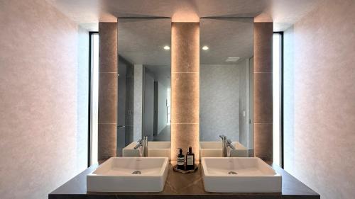 a bathroom with two sinks and a large mirror at CIN Garden Terrace in Futtsu