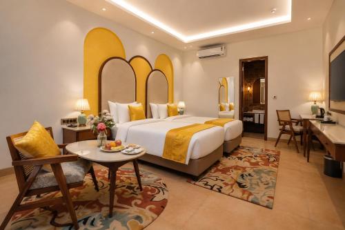 a hotel room with a large bed and a table at Kadamb Kuteer Hotel and Resort in Chhatikara