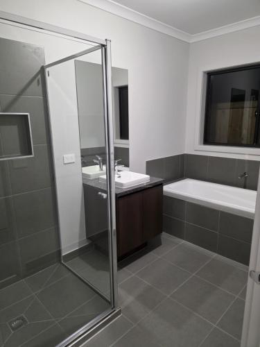 a bathroom with a shower and a sink and a tub at 11 Lomond street in Beveridge