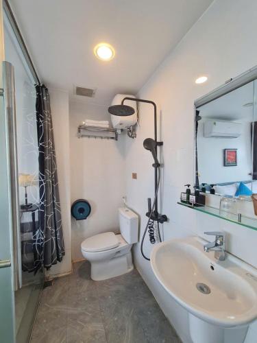 a bathroom with a white toilet and a sink at SUN HOTEL in Hue