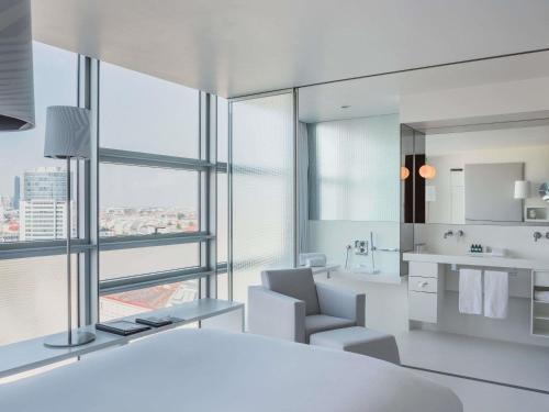 a white bathroom with a view of a city at SO/ Vienna in Vienna