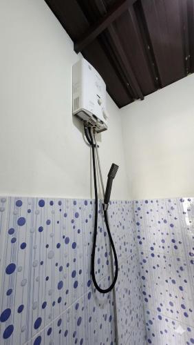 a blow dryer on the wall of a bathroom at Hajeka Family 1 in Palayangan