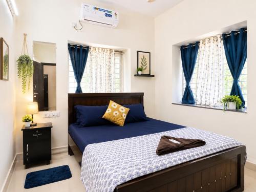 a bedroom with a bed with blue sheets and blue curtains at Indigo Homes Kondapur in Hyderabad
