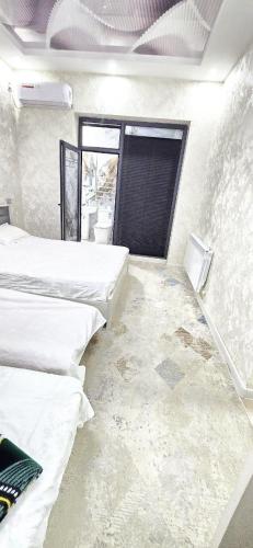 a room with two beds and a window at Centre Cheap Hotel in Tashkent