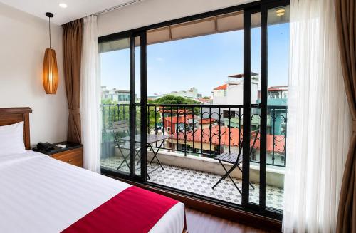 a bedroom with a bed and a view of a balcony at Golden Moon Suite Hotel & Travel in Hanoi