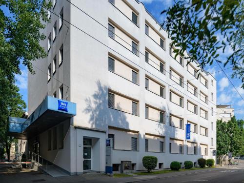 a white building with a blue sign on it at ibis budget Hotel Luzern City in Lucerne