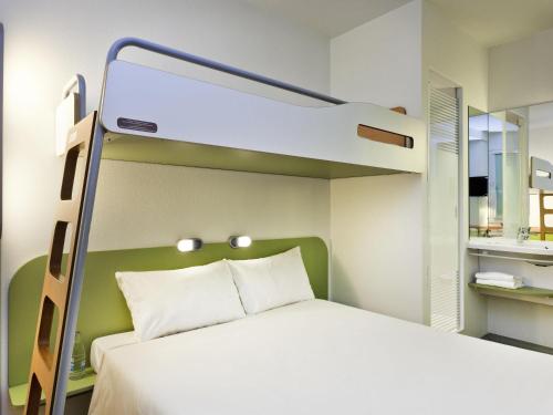 a bed in a room with a bunk bed at ibis budget Winterthur in Winterthur