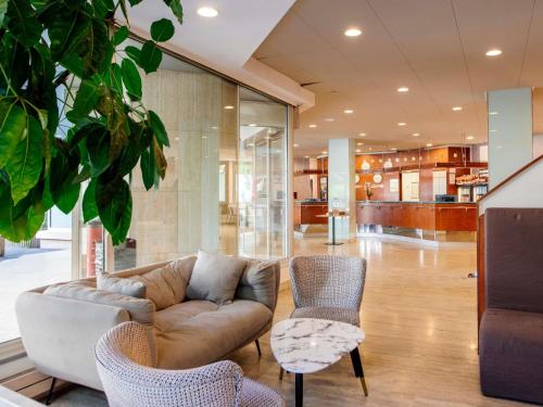 a living room with a couch and chairs at Aparthotel Adagio Paris XV in Paris
