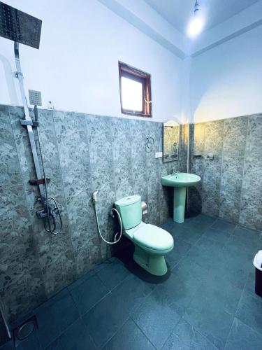 a bathroom with a toilet and a shower and a sink at Samadhi Nature Resort in Ella