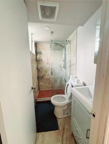 a bathroom with a shower and a toilet and a sink at Beautiful Family-Friendly privet basement in Brossard