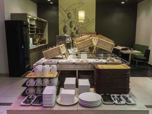 a restaurant with plates and dishes on a table at ibis Oran les Falaises in Oran