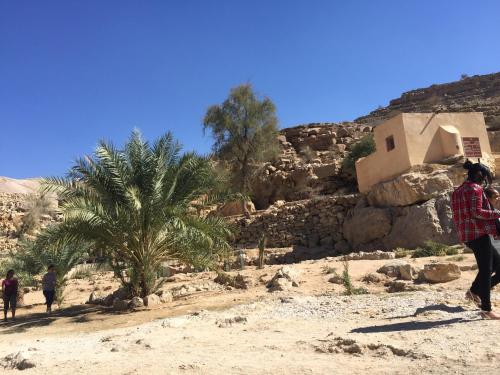 a group of people walking in the desert with a building at Oriental Nights Rest House in Al Wāşil