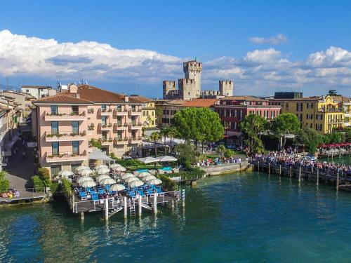 a view of a river with chairs and buildings at Hotel Eden in Sirmione