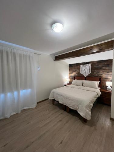 a bedroom with a large bed and a wooden wall at Agradable y Acogedora Casa Moderna en Puerto Varas in Puerto Varas
